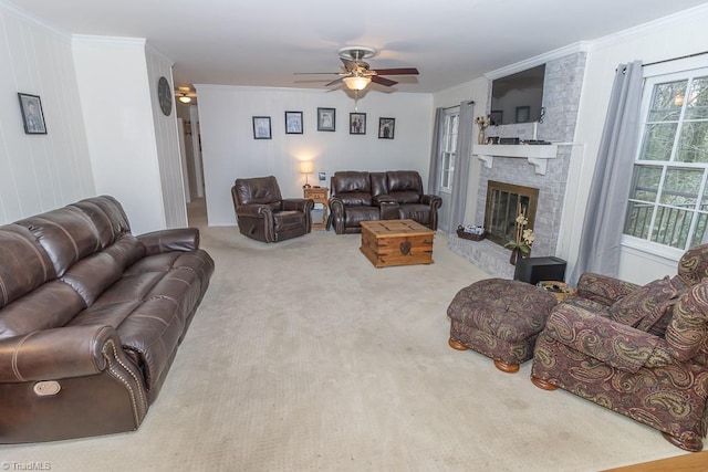 living room featuring carpet flooring, ceiling fan, crown molding, and a fireplace