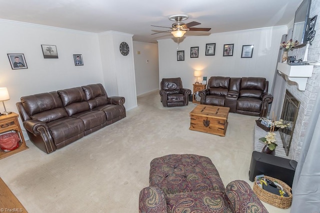 carpeted living room with a fireplace, ceiling fan, and crown molding