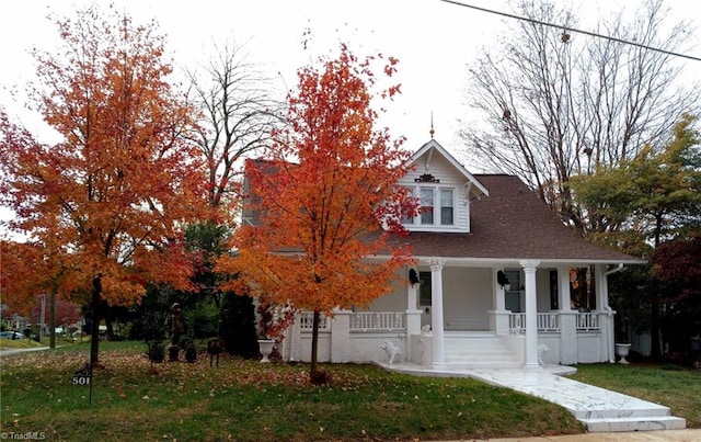 view of front of home featuring covered porch and a front lawn