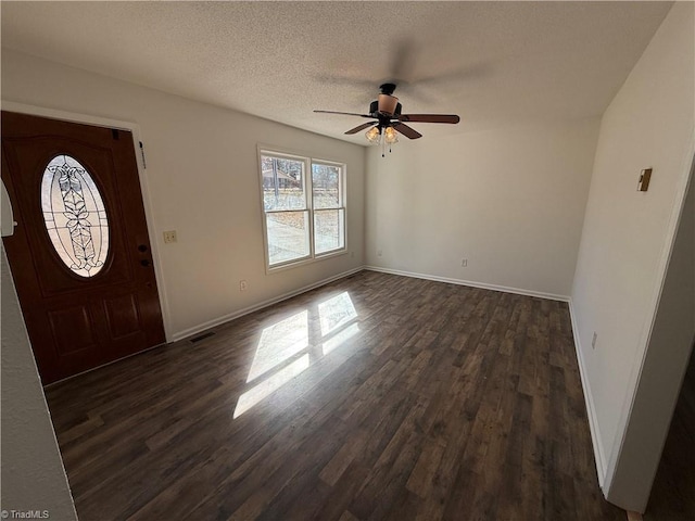 entryway with dark wood-type flooring, a textured ceiling, and ceiling fan