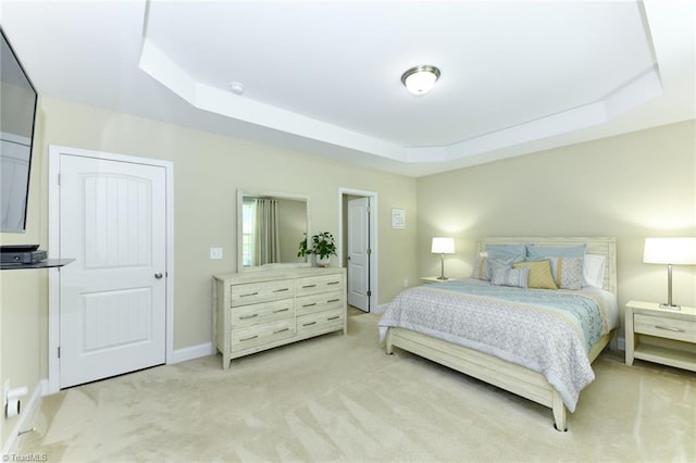 carpeted bedroom with a raised ceiling