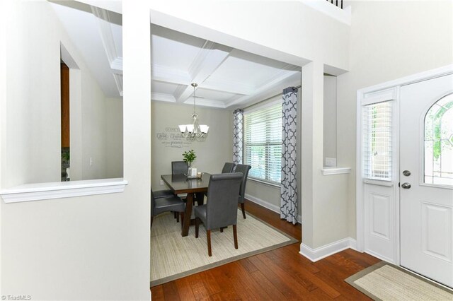 dining space featuring coffered ceiling, beamed ceiling, a chandelier, and dark wood-type flooring