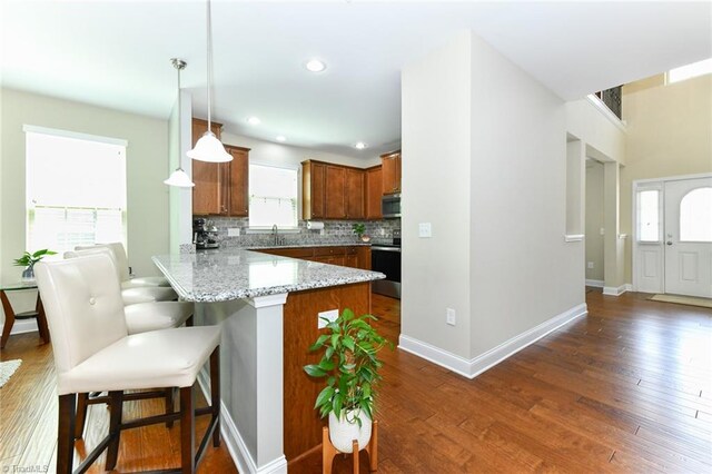 kitchen featuring kitchen peninsula, black range with electric cooktop, and dark hardwood / wood-style flooring