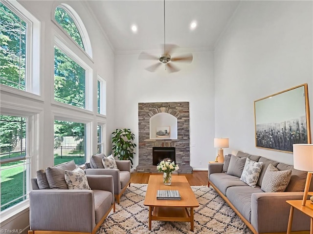 350 Bent Creek Trl, Kernersville, NC 27284 - living room featuring a towering ceiling, ceiling fan, wood finished floors, crown molding, and a fireplace