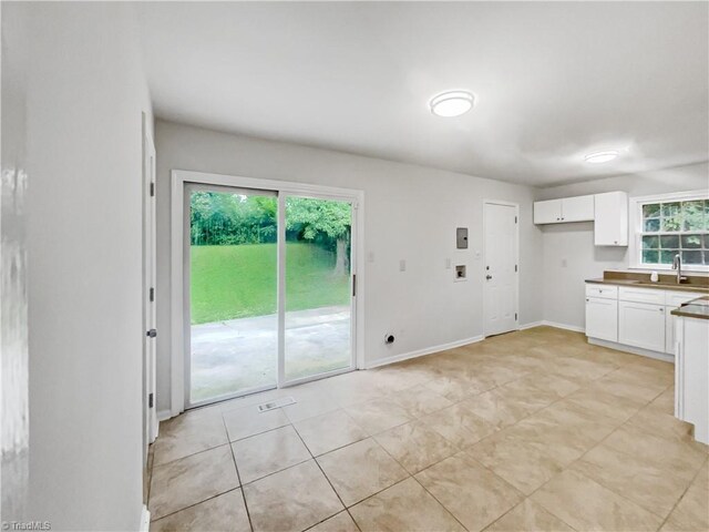 1606 Woodbriar Ave, Greensboro, NC 27405 - kitchen featuring white cabinetry, light tile patterned floors, and dark countertops