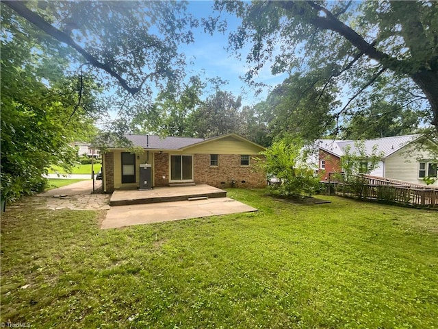 1606 Woodbriar Ave, Greensboro, NC 27405 - back of property featuring a patio, a lawn, and brick siding