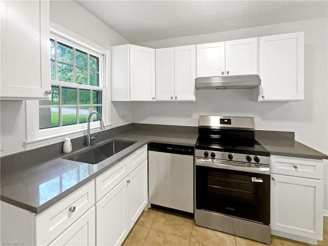 1606 Woodbriar Ave, Greensboro, NC 27405 - kitchen featuring stainless steel appliances, under cabinet range hood, white cabinetry, and dark countertops