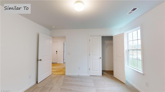 unfurnished bedroom featuring light colored carpet and a closet