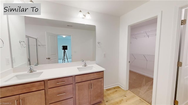 bathroom featuring a shower with door, wood-type flooring, and vanity