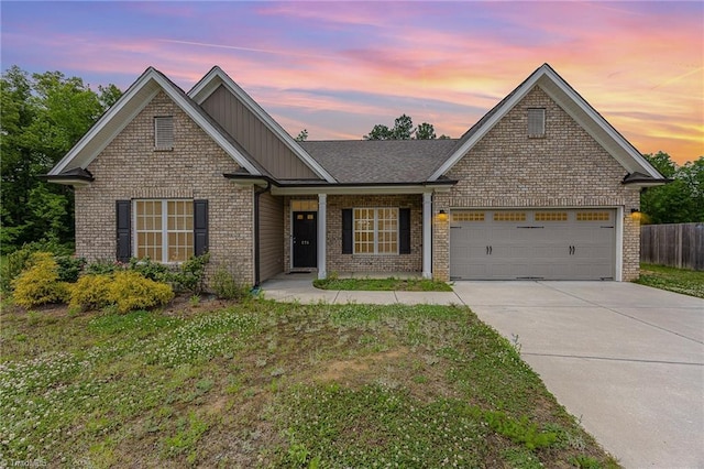 275 Obsidium Ct, Gibsonville, NC 27249 - view of front of property with board and batten siding, brick siding, concrete driveway, and a garage