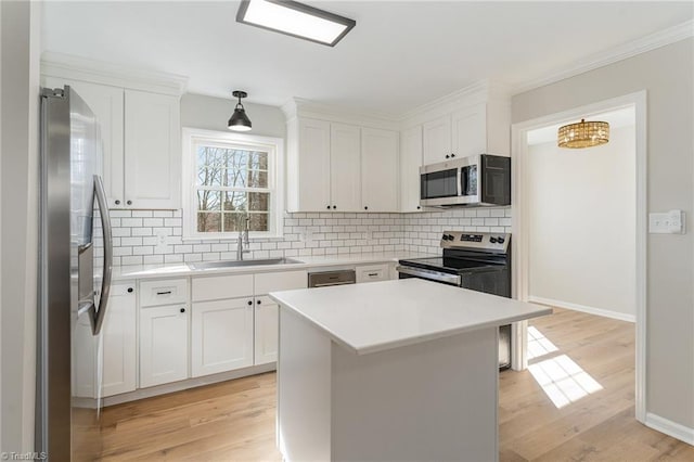 kitchen featuring appliances with stainless steel finishes, a sink, and white cabinetry