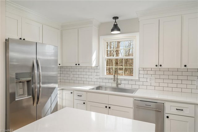 kitchen with tasteful backsplash, appliances with stainless steel finishes, light countertops, and a sink