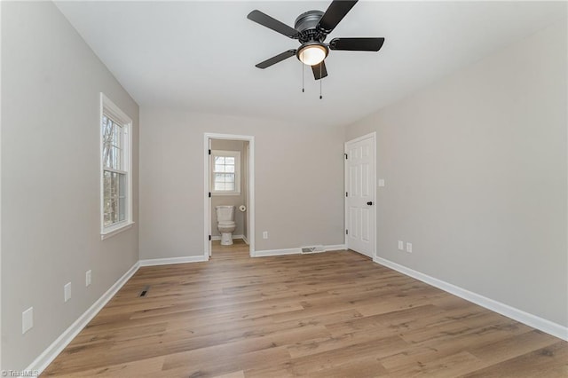 interior space featuring ceiling fan, light wood-style flooring, and baseboards