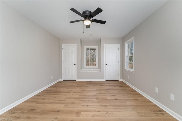 unfurnished room featuring light wood-type flooring, a ceiling fan, and baseboards