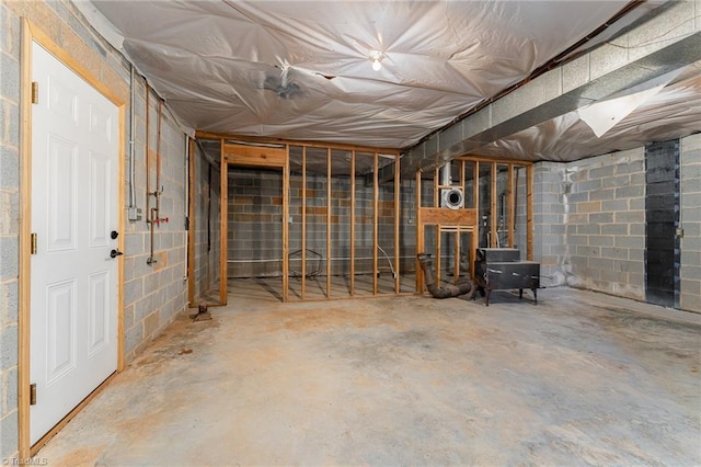 unfinished basement featuring concrete block wall