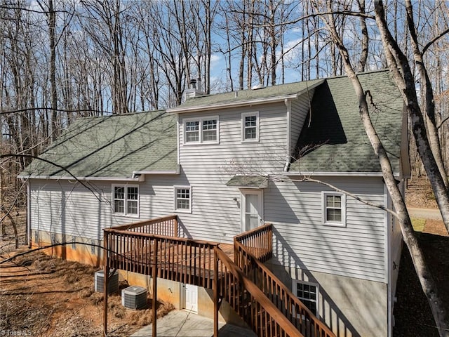 rear view of house featuring stairway, roof with shingles, a deck, and central AC unit