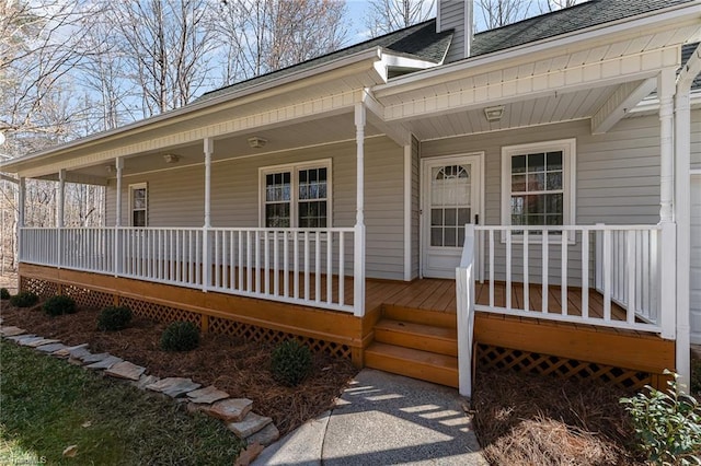 doorway to property featuring a porch, roof with shingles, and a chimney