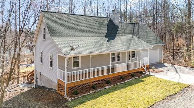 view of front of house featuring roof with shingles, a chimney, a porch, driveway, and a front lawn