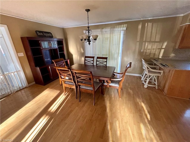 dining area featuring crown molding, light hardwood / wood-style floors, and a notable chandelier