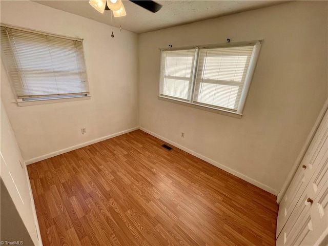 empty room with ceiling fan and light wood-type flooring