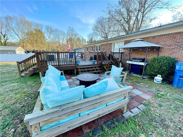 wooden deck featuring a gazebo, a grill, a yard, and a fire pit