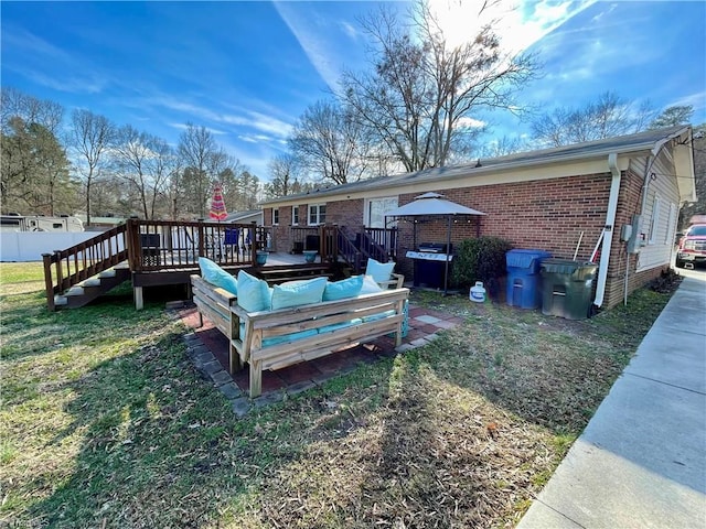 back of house with a gazebo, a wooden deck, and a lawn