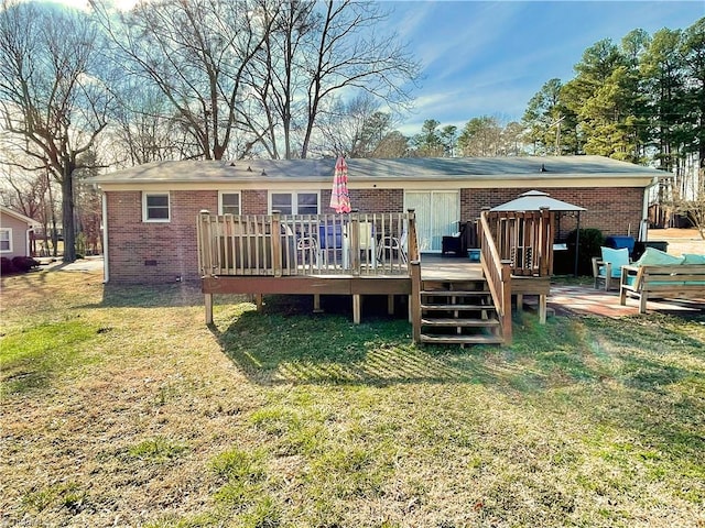 rear view of property with a deck and a lawn