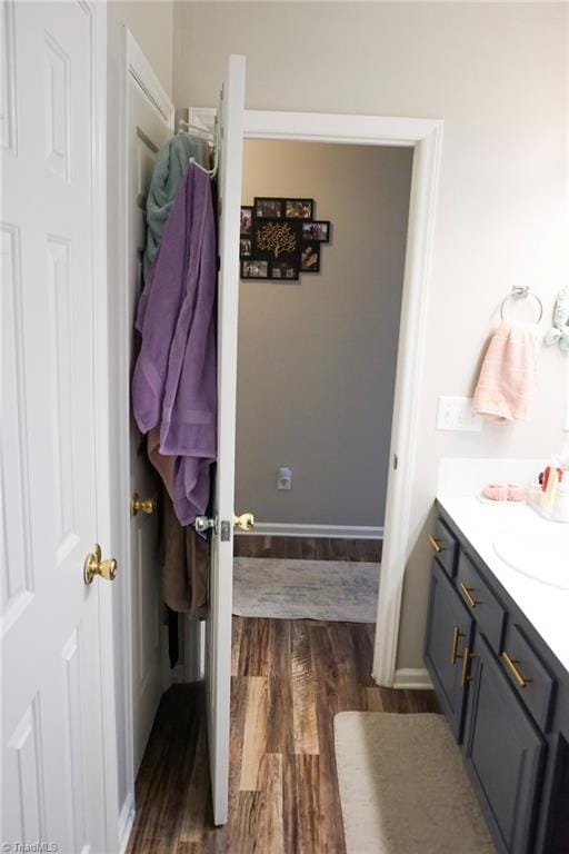 bathroom featuring wood finished floors, vanity, and baseboards