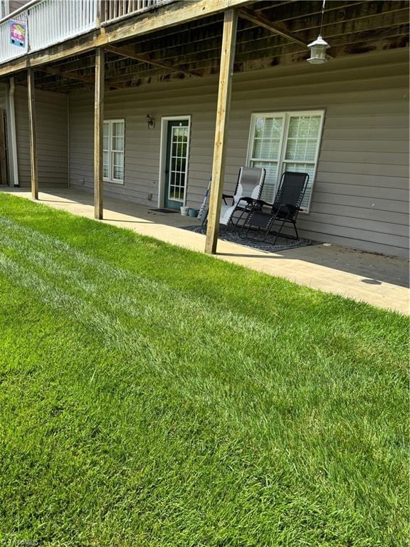 back of property with a yard and a deck