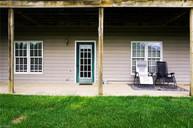 property entrance featuring a patio and a lawn