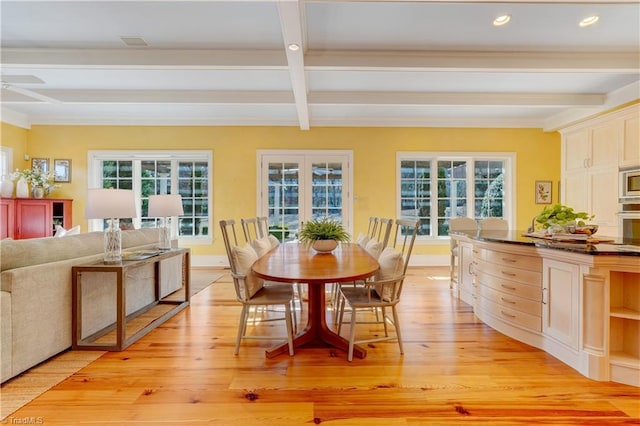 dining space with plenty of natural light, beam ceiling, and light wood-type flooring