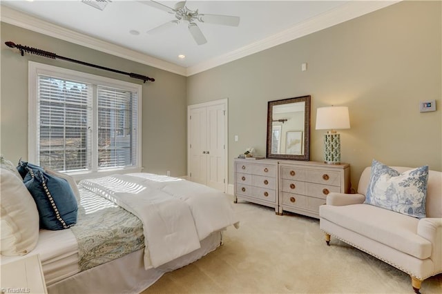 bedroom featuring ornamental molding, light carpet, ceiling fan, and a closet