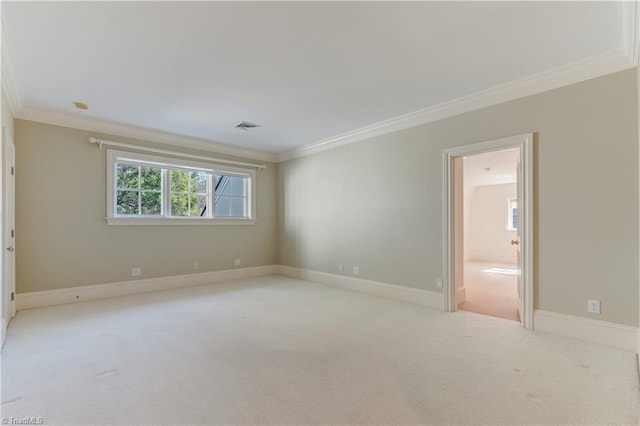 empty room featuring ornamental molding and light colored carpet