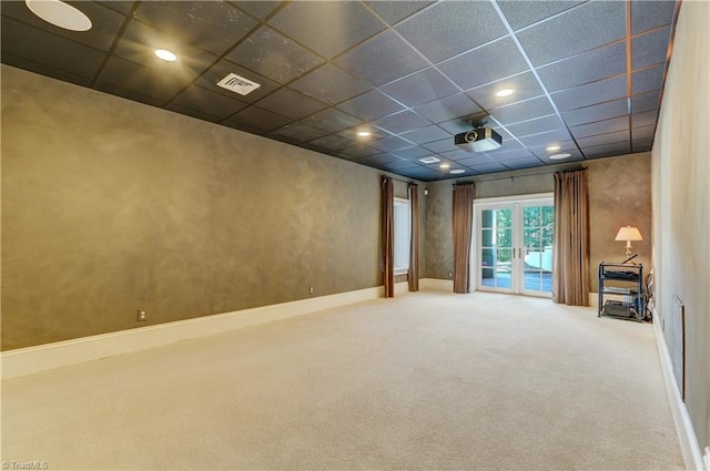 interior space with french doors, carpet flooring, and a drop ceiling