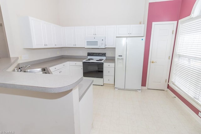 2221314 Delaney Dr, Burlington, NC 27215 - kitchen featuring white appliances, a sink, a peninsula, light countertops, and baseboards