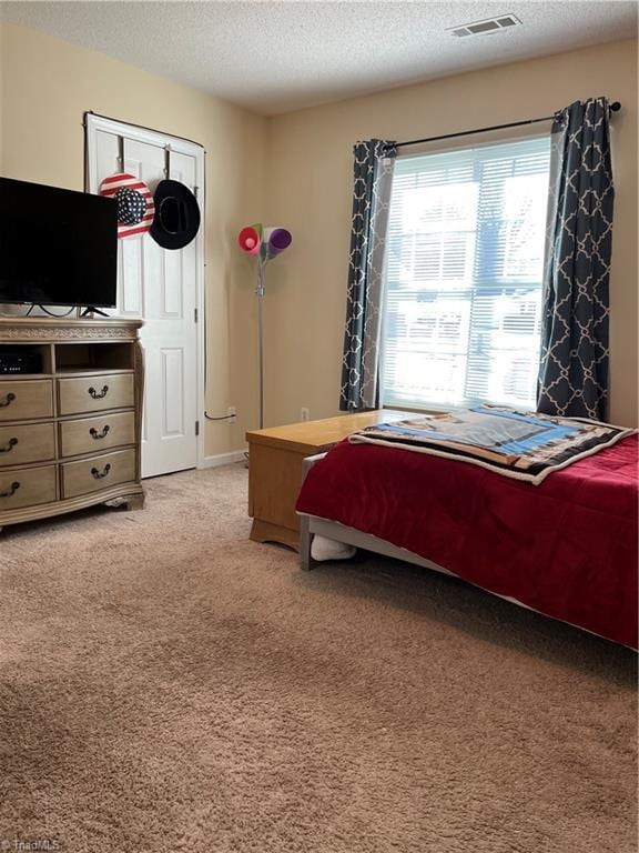 carpeted bedroom with a textured ceiling