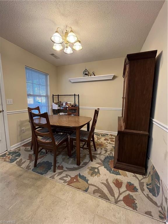 dining room featuring a notable chandelier and a textured ceiling