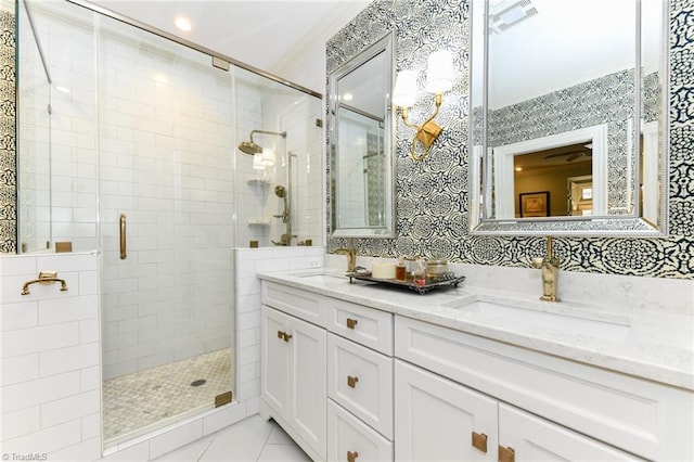 full bathroom featuring double vanity, visible vents, a stall shower, and a sink