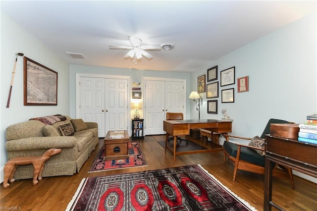 living area with visible vents, wood finished floors, and a ceiling fan