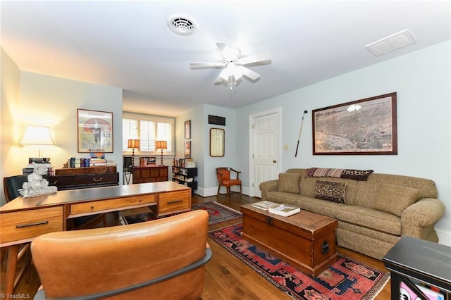 living area with visible vents, baseboards, a ceiling fan, and wood finished floors