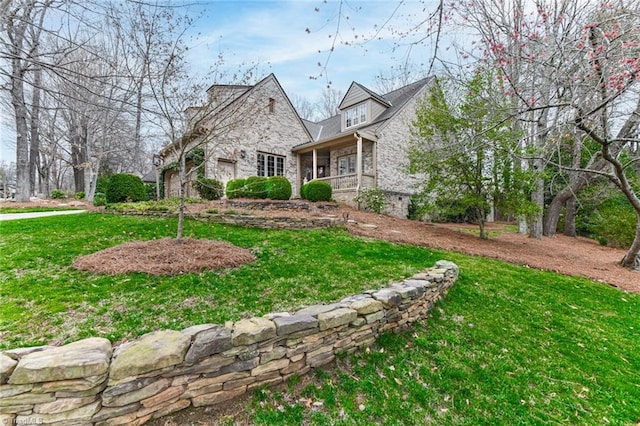 view of front of property with a front yard and stone siding