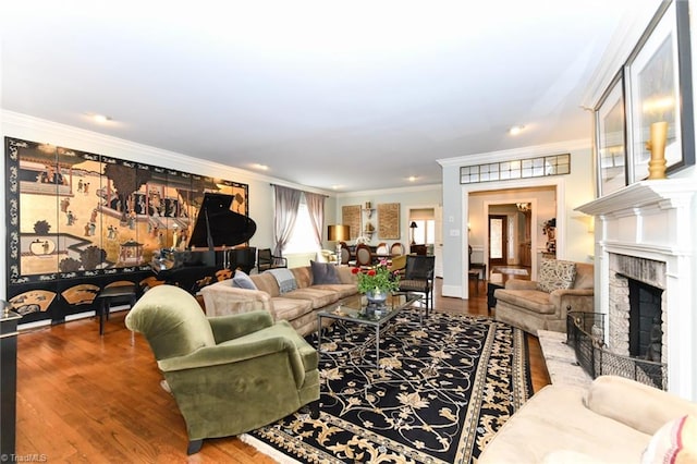 living area with wood finished floors, a fireplace, and crown molding