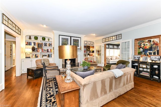 living area with french doors, built in shelves, wood finished floors, and crown molding