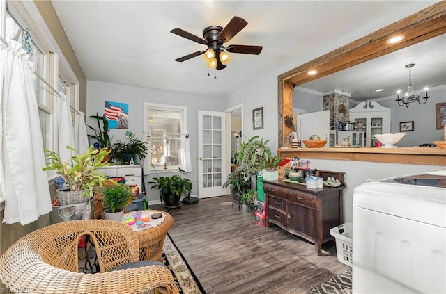 interior space featuring crown molding, dark wood-type flooring, and ceiling fan with notable chandelier