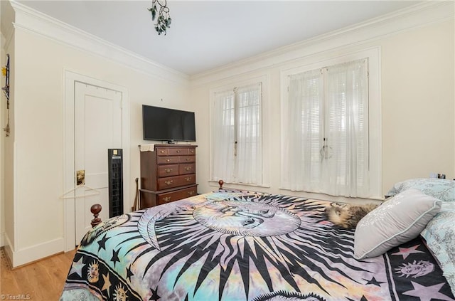 bedroom with light hardwood / wood-style flooring and ornamental molding