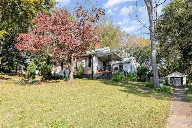 view of front of house featuring a garage, a front lawn, a porch, and an outdoor structure