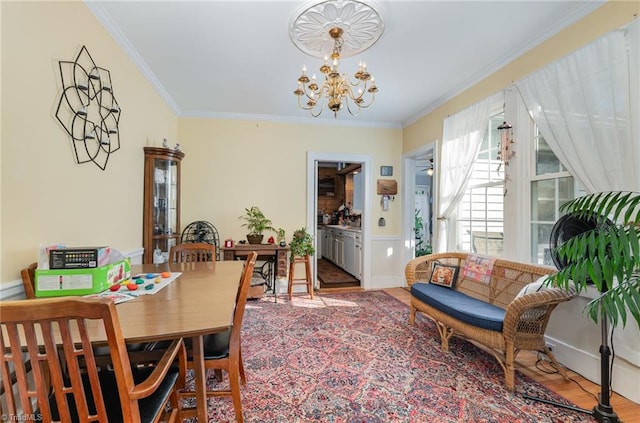 dining space with crown molding, a notable chandelier, and hardwood / wood-style floors