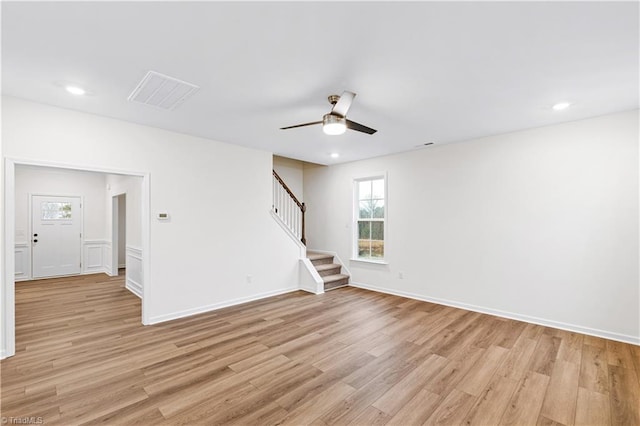 empty room featuring light wood finished floors, visible vents, stairway, recessed lighting, and a ceiling fan