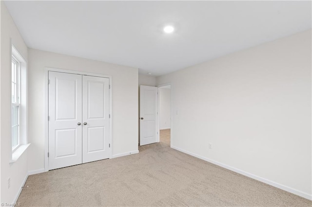 unfurnished bedroom featuring a closet, carpet flooring, and baseboards