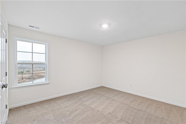 empty room featuring visible vents, baseboards, and carpet floors